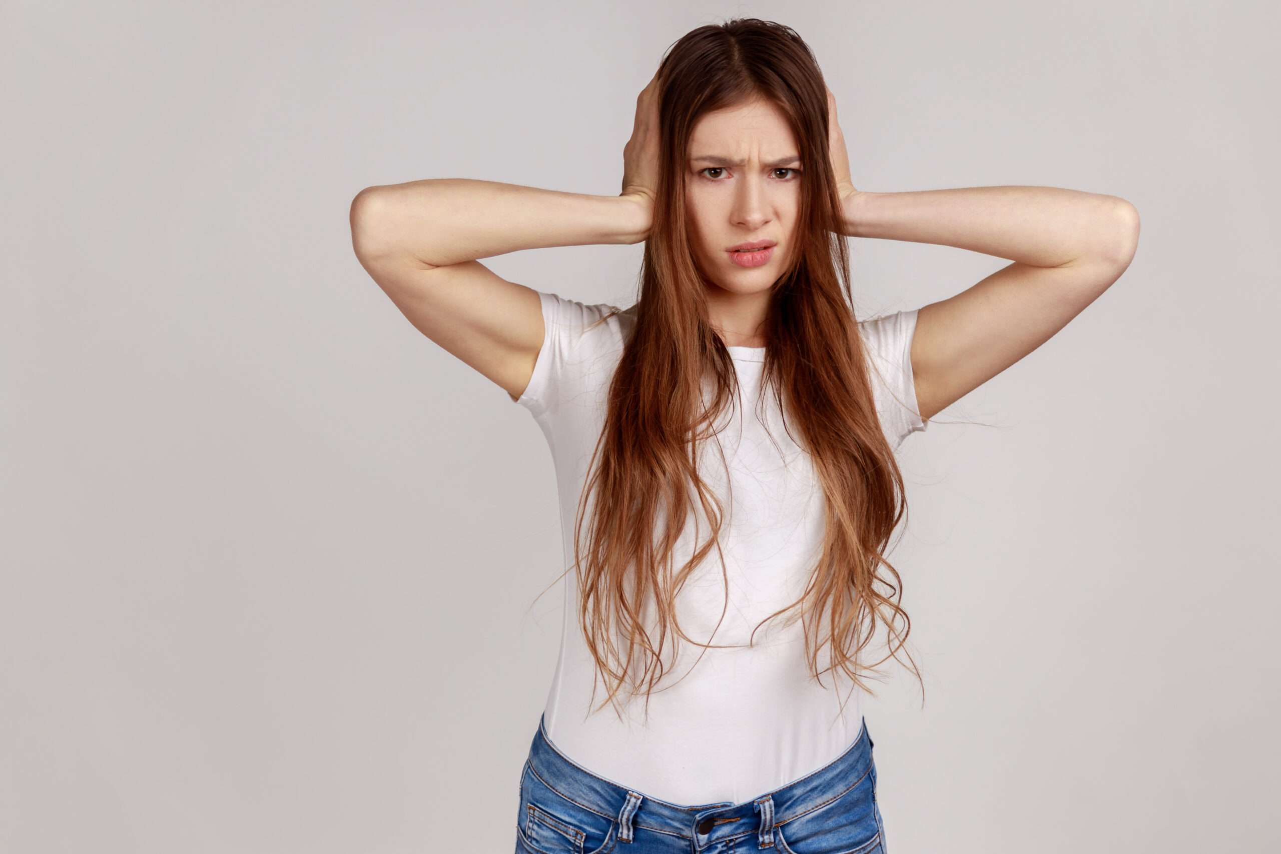 A young woman shielding her ears from holiday stress.