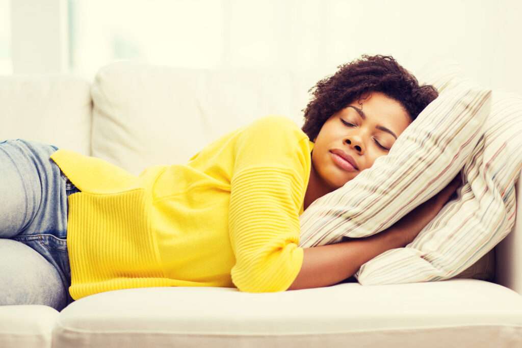 A woman sleeping on a couch, understanding Seasonal Affective Disorder.